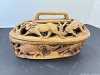 Front view of oval carved bowl showing elephant and antelope figures