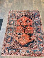 Full view of rectangular Persian rug showing overall pattern and colors