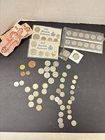 Full lot overview showing banknotes, packaged sets, loose coins