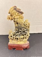 Full view of soapstone landscape carving on wood stand