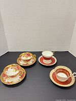 All four cup and saucer sets grouped
