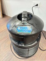 Top view of FilterQueen Defender showing handle, control panel, dust, and power cord