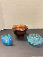 Group shot of red footed bowl, blue swan, blue bowl