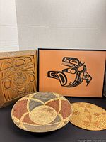 Group shot of framed print, carved wood panel, woven bowl and trivet