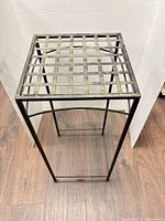 Full view of metal plant stand showing lattice top and legs