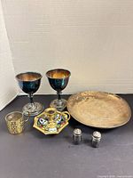 Full group showing two goblets, brass cup, candlestick on enamel base, brass plate, salt & pepper shakers