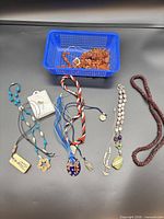 Overview of all necklaces, boxed opal pendant and basket of amber-like beads
