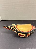 Side view of carved raven bowl showing painted details and interior