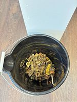 Top view of bucket showing mixed brass fittings, fasteners, screwdriver