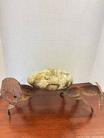 Full view of stone-body crab figure on wood surface