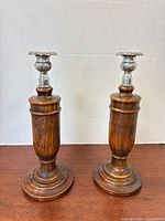 Two wood candlesticks upright on table