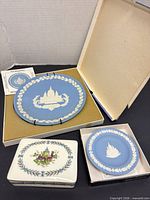 Group shot of large and small Jasperware plates, trinket box, and original boxes