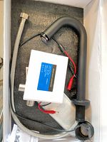 Box contents showing matte black spout, white control box, braided hose, wiring