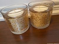 Two cylindrical LED candles in glass holders