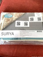 Front of sealed package showing Surya branding and size 2' x 8'