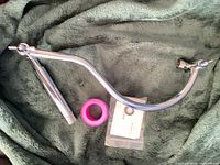 Overall view of shower arm, thread-seal tape and instruction packet on cloth background