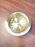 Top view of brushed brass basket strainer inserted in flange