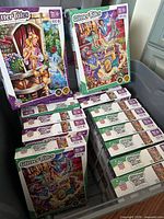 Bin containing multiple sealed Glitter Tales puzzle boxes