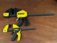 Both DeWalt trigger clamps on surface