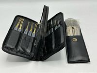 Open zippered case and closed snap pouch displaying lock pick sets