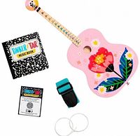 Kit contents laid out: guitar, strap, music book, spare strings