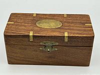 Closed wooden box showing brass inlay and latch