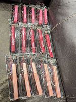 All 15 Jordache lip glosses displayed on leather surface
