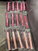 All 15 packaged lip glosses laid out showing three color groups