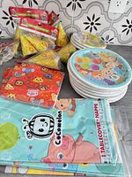Assorted Cocomelon party hats, napkins, plates, tablecovers in packaging
