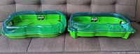 Both Beyblade Burst stadiums side by side on sofa showing overall condition and color
