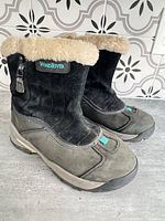 Front three-quarter view showing both boots, brand logo, faux-fur collar and overall condition
