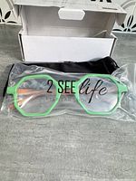 Glasses in plastic sleeve, retail box behind