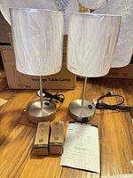 Both table lamps with shades wrapped, bases visible, LED bulbs and manual on floor