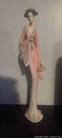 Front view of tall pink porcelain geisha figurine