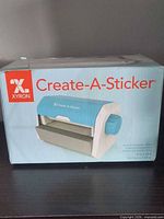 Front of sealed Xyron Create-A-Sticker box showing product image and cartridge size