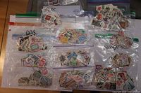 Overview of ten Ziploc bags containing assorted stamps