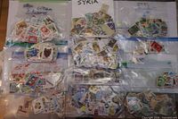 Overview showing twelve labelled bags filled with stamps