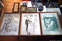 All seven items laid out: three large framed sheet music covers, four smaller framed pieces and plaque