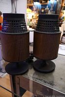 Front view of both Electrohome cylindrical speakers on glass table