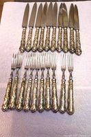 Full set of 10 knives and 10 forks laid out