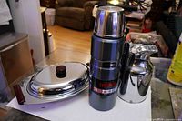 All three items grouped: serving dish with lid, pitcher, Thermos flask