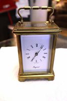 Front view of brass carriage clock with handle and dial visible