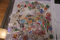 Overview of entire bag with numerous loose stamps visible