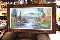 Framed landscape oil painting on chair