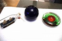 All three items: ship in bottle, blue sphere paperweight, green spiral paperweight