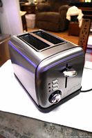 Front three-quarter view showing stainless housing, dual slots, control lever and buttons