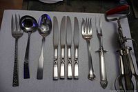 Full set of utensils laid out on white surface