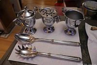 Overall view of three chrome bowls and two silverplated utensils