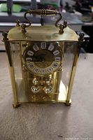 Front view showing brass frame, dial, pendulum