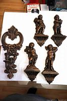Group shot of four cherub plaques and single candle sconce